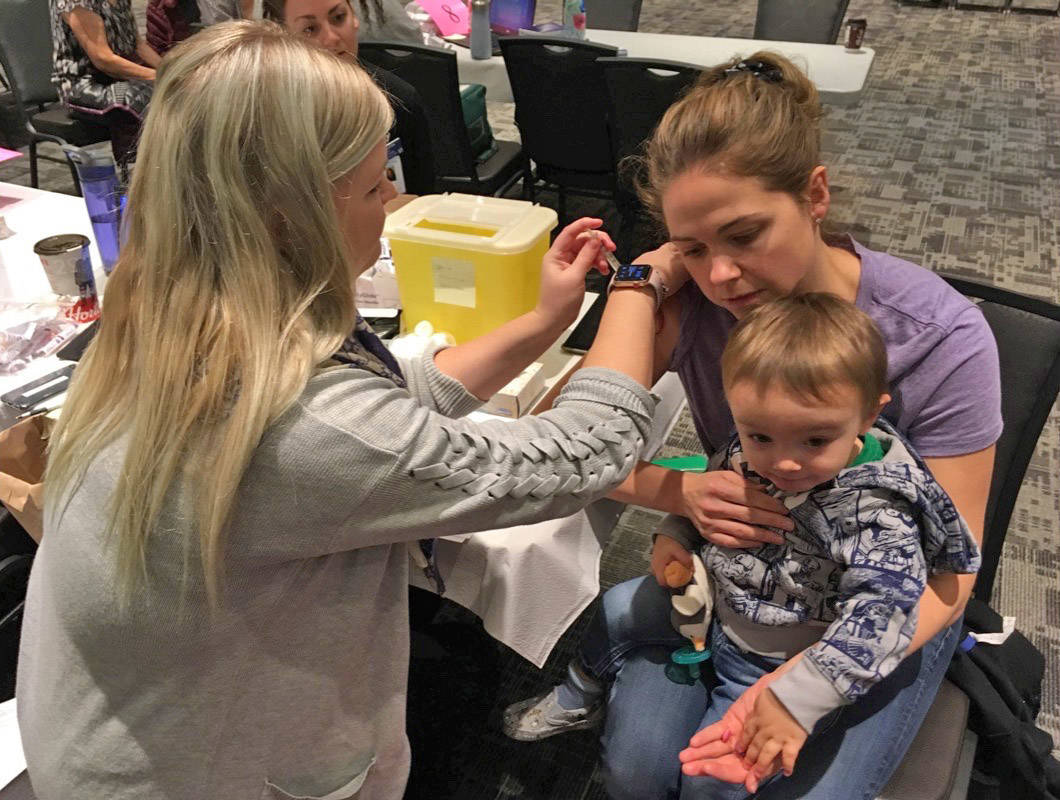 Local resident Amber Whitford receives her influenza immunization holding her son Matthew McKenzie Monday morning at the Harvest Centre. Mark Weber/Red Deer Express