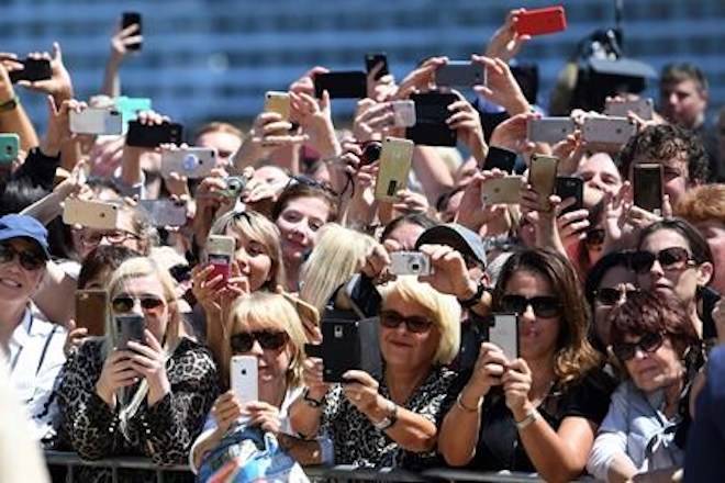 Members of the public wait outside the Opera House to meet Britain’s Prince Harry and Meghan, Duchess of Sussex in Sydney, Australia, Tuesday, Oct. 16, 2018. (Dan Himbrechts/Pool via AP)