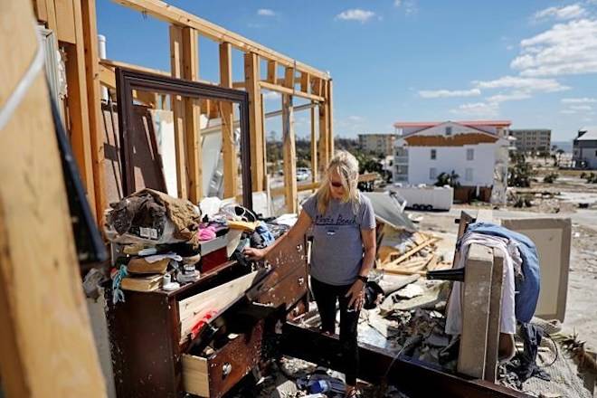 Candace Phillips sifts through what was her third-floor bedroom while returning to her damaged home in Mexico Beach, Fla., Sunday, Oct. 14, 2018, in the aftermath of Hurricane Michael. “We spent 25 years of our marriage working to get here and we’re going to stay,” said Phillips of her and husband’s plans to rebuild. (AP Photo/David Goldman)