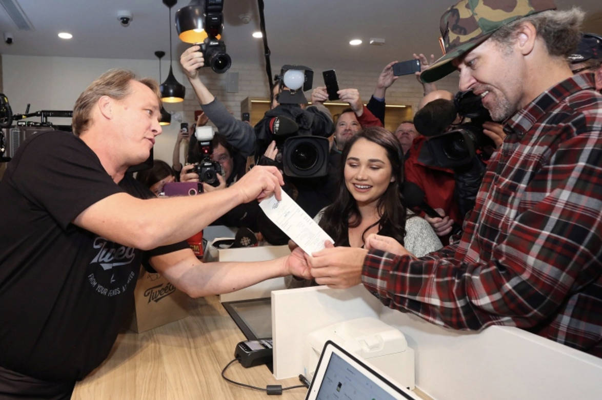 Canopy Growth CEO Bruce Linton, left to right, provides the receipt for the first legal cannabis for recreation use sold in Canada to Nikki Rose and Ian Power at the Tweed shop on Water Street in St. John’s N.L. at 12:01 am NDT on Wednesday October 17, 2018. (Paul Daly/The Canadian Press)