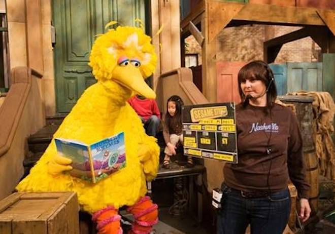 FILE- In this April 10, 2008, file photo Lynn Finkel, stage manager for “Sesame Street” slates a taping with Big Bird in New York.(AP Photo/Mark Lennihan, File)