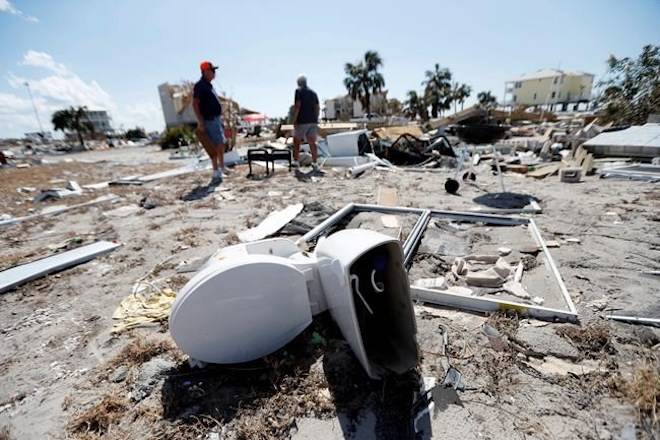 Neighbors Bob Coleman, left, and Ron Adkisson, search the sites of their former homes in the aftermath of Hurricane Michael in Mexico Beach, Fla., Wednesday, Oct. 17, 2018. (AP Photo/Gerald Herbert)