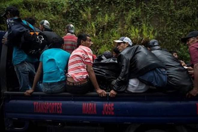 Migrants from Honduras ride on a pick-up truck towards the Mexican border, in Cocales, about 80 miles north-west from Guatemala City, Guatemala, Thursday, Oct. 18, 2018. (AP Photo/ Oliver de Ros)