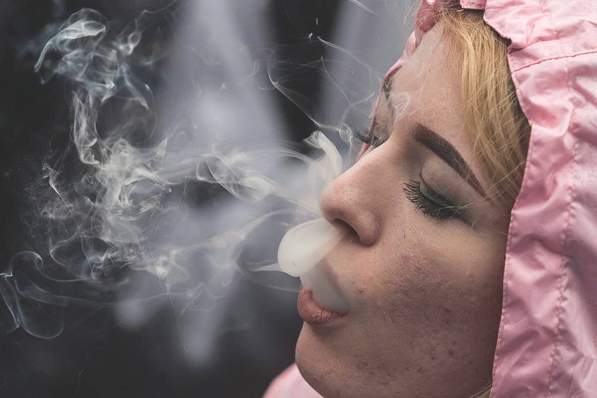 FILE - In this April 20, 2018 file photo, a woman exhales while smoking a joint during the 4-20 annual marijuana celebration, in Vancouver, British Columbia. (Darryl Dyck/The Canadian Press via AP, File)