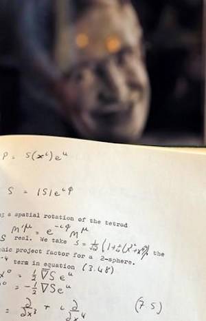 A Book, written and corrected with handwritten annotation by Stephen Hawking is one of the personal and academic possessions of Stephen Hawking, photo behind, on display at the auction house Christies in London, Friday, Oct. 19, 2018.(AP Photo/Frank Augstein)