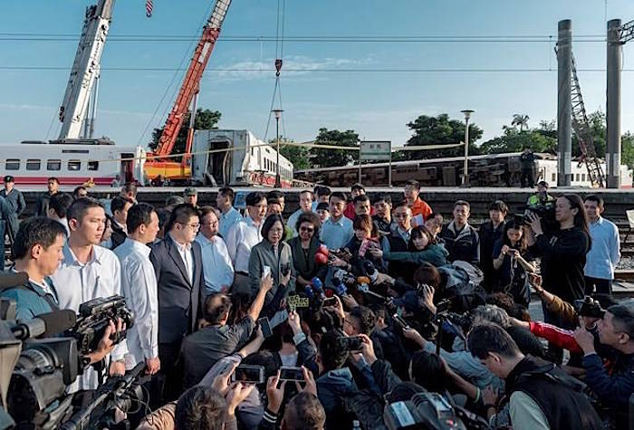 In this photo released by the Taiwan Presidential Office, Taiwanese President Tsai Ing-wen, center, briefs journalists at the site of a train derailment in Yilan county in northeastern Taiwan on Monday, Oct. 22, 2018. (Taiwan Presidential Office via AP)