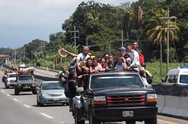 Central American migrants making their way to the U.S. in a large caravan fill the truck of a driver who offered them the free ride, as they arrive to Tapachula, Mexico, Sunday, Oct. 21, 2018. (AP Photo/Moises Castillo)