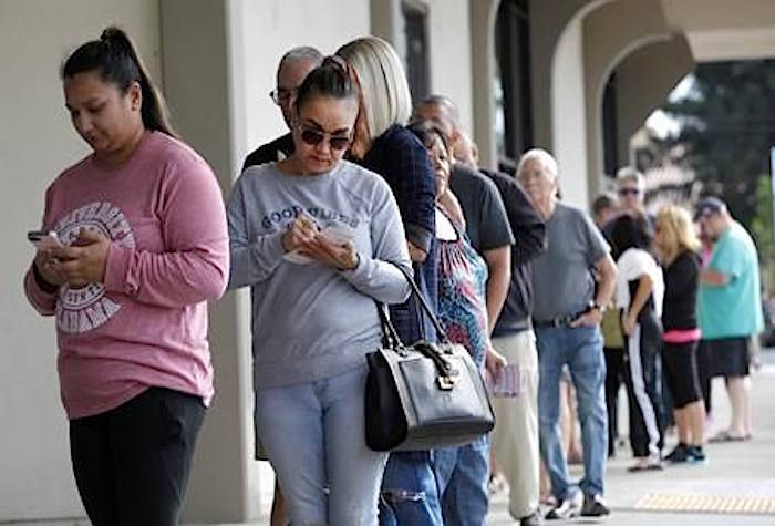 Lotto players wait in line to purchase lottery tickets for the Mega Millions lottery at Lichines Liquor & Deli, Tuesday, Oct. 23, 2018, in Sacramento, Calif. Lottery players will have the chance at winning an estimated $1.6 billion in Tuesday’s Mega Millions drawing. (AP Photo/Rich Pedroncelli)