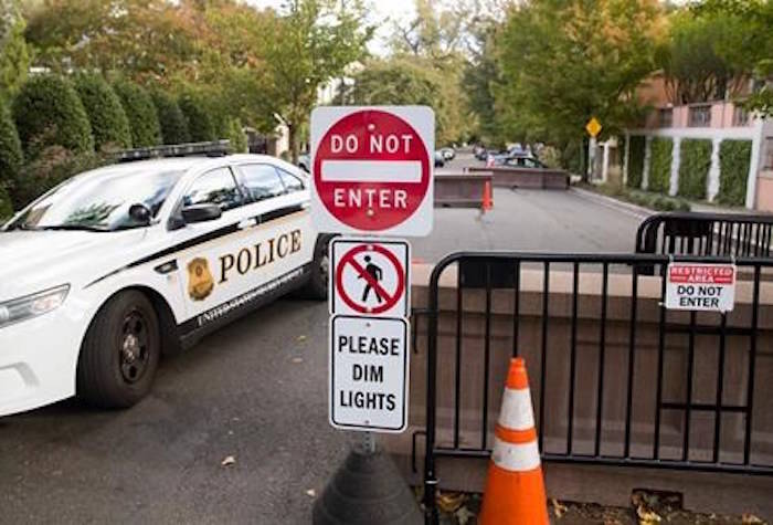 An officer with the Uniform Division of the United States Secret Service sits in his car at a checkpoint near the home of President Barack Obama, Wednesday, Oct. 24, 2018, in Washington. The U.S. Secret Service says agents have intercepted packages containing “possible explosive devices” addressed to former President Barack Obama and Hillary Clinton. (AP Photo/Alex Brandon)