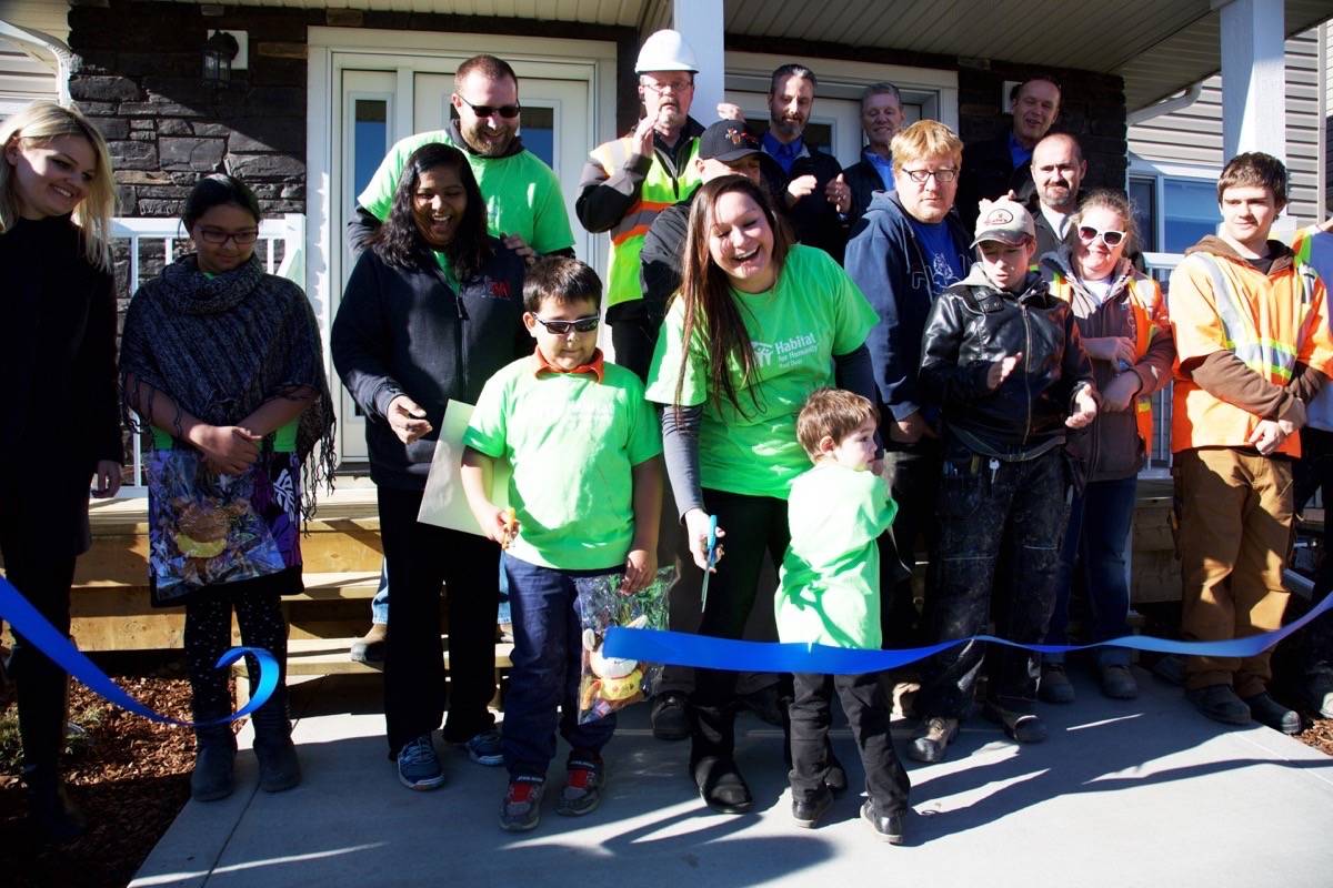 The Rodriguez and Brown families cut the ribbon to their new homes on Thursday. The homes were built over the past eight months by Habitat for Humanity volunteers and partners. Robin Grant/Red Deer Express.