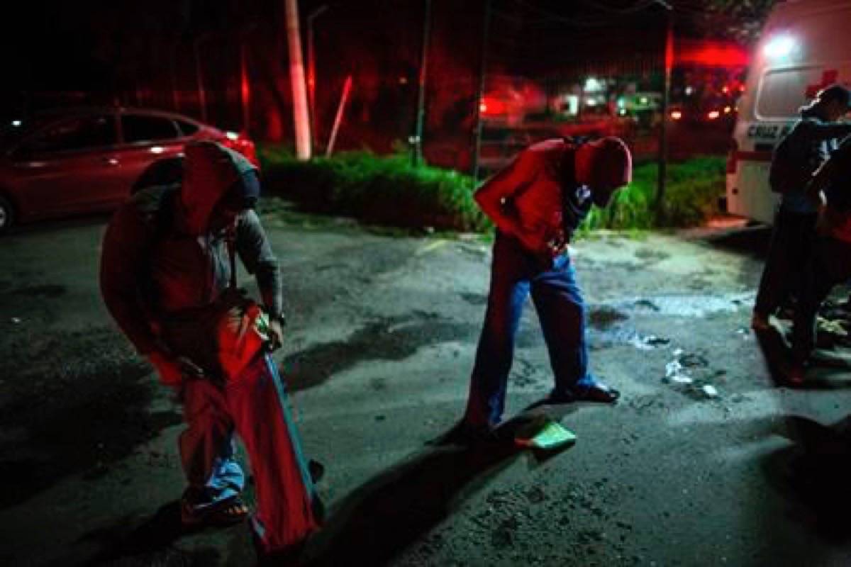 Central American migrants, part of the caravan hoping to reach the U.S. border, dress with donated trousers due to the cold temperature while traveling during the night on a truck in Orizaba, Veracruz state, Mexico, Saturday, Nov. 3, 2018. (AP Photo/Rodrigo Abd)