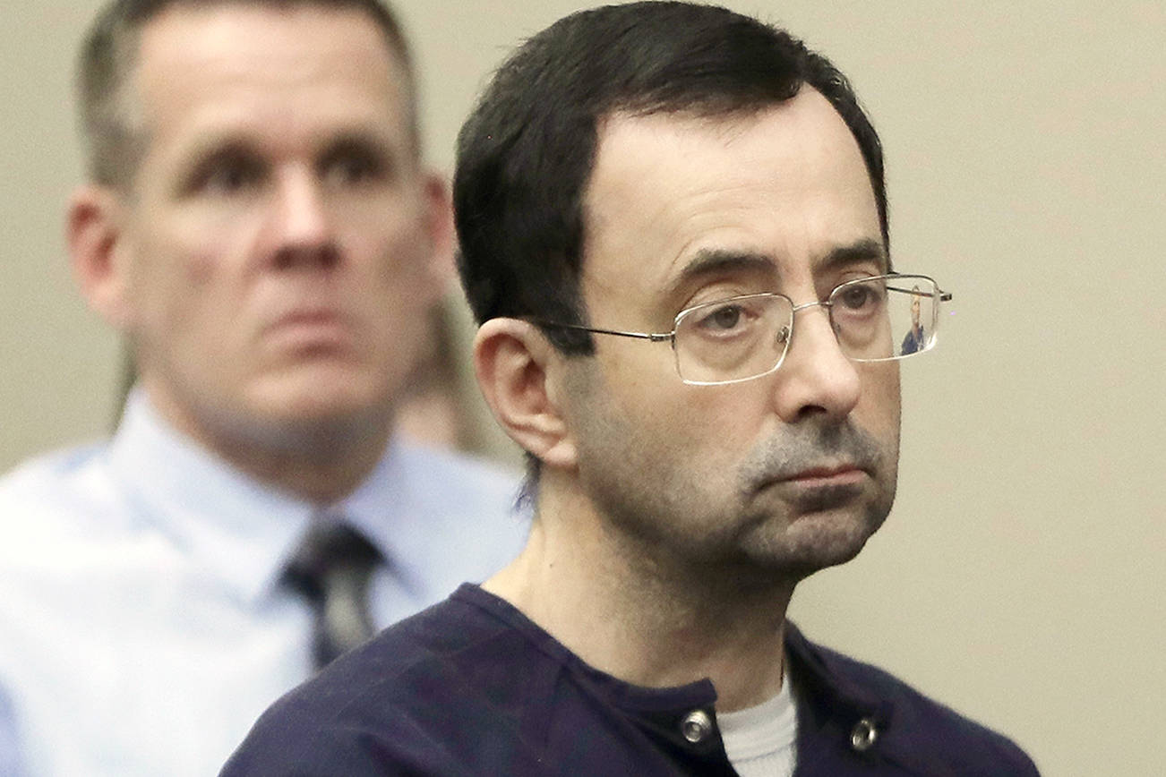 FILE - In this Jan. 24, 2018, file photo, Larry Nassar sits during his sentencing hearing in Lansing, Mich. Lawyers for the imprisoned former sports doctor on Tuesday, July 24, 2018, filed motions in Ingham County asking that he be re-sentenced by a different judge in the first of the major molestation cases he faced. Nassar, who’s serving a 60-year federal sentence for possessing child pornography, was also sentenced to up to 175 years in state prison for molesting young athletes. (AP Photo/Carlos Osorio, File)