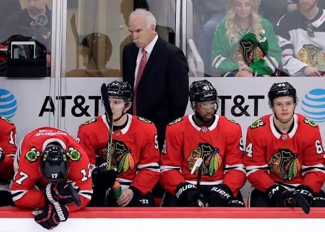 Chicago Blackhawks head coach Joel Quenneville, top, and his players react as they watch their team during the third period of an NHL hockey game against the Detroit Red Wings, Sunday, Jan. 14, 2018, in Chicago. THE CANADIAN PRESS/AP, Nam Y. Huh