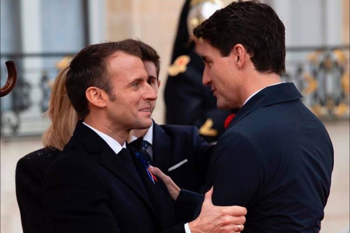 French President Emmanuel Macron greets Prime Minister Justin Trudeau as he arrives at the Palais de l’Elysee in Paris, France Sunday November 11, 2018. (Adrian Wyld/The Canadian Press)