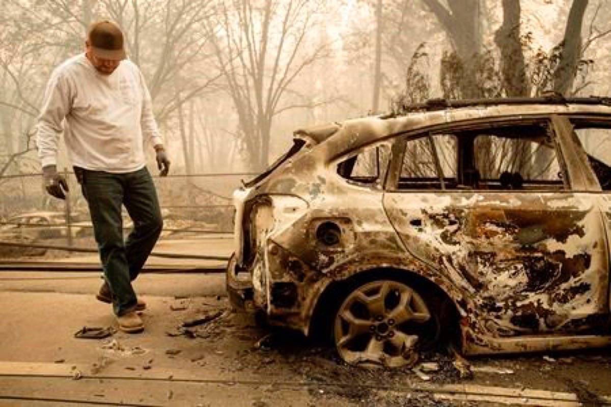 Eric England searches through a friend’s vehicle on Pearson Rd. after the wildfire burned through Paradise, Calif., on Saturday, Nov. 10, 2018. Not much is left in Paradise after a ferocious wildfire roared through the Northern California town as residents fled and entire neighbourhoods are levelled. (AP Photo/Noah Berger)