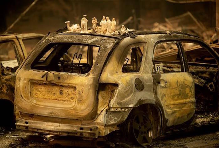 Following the Camp Fire, figurines rest atop a scorched car on Pearson Road, Monday, Nov. 12, 2018, in Paradise, Calif. (AP Photo/Noah Berger)