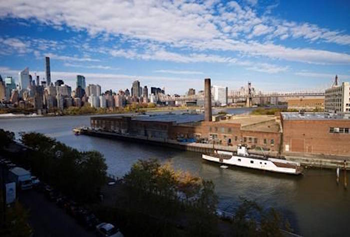 In this Wednesday, Nov. 7, 2018, photo, a rusting ferryboat is docked next to an aging industrial warehouse on Long Island City’s Anable Basin in the Queens borough of New York. Across the East River is midtown Manhattan, top left. Long Island City is a longtime industrial and transportation hub that has become a fast-growing neighborhood of riverfront high-rises and redeveloped warehouses, with an enduring industrial foothold and burgeoning arts and tech scenes. (AP Photo/Mark Lennihan)