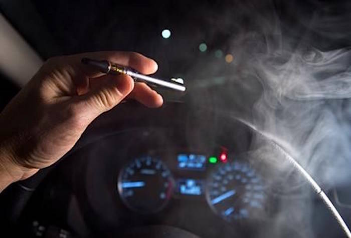 In this photo illustration, smoke from a cannabis oil vaporizer is seen as the driver is behind the wheel of a car in North Vancouver, B.C. Wednesday, Nov. 14, 2018. THE CANADIAN PRESS /Jonathan Hayward