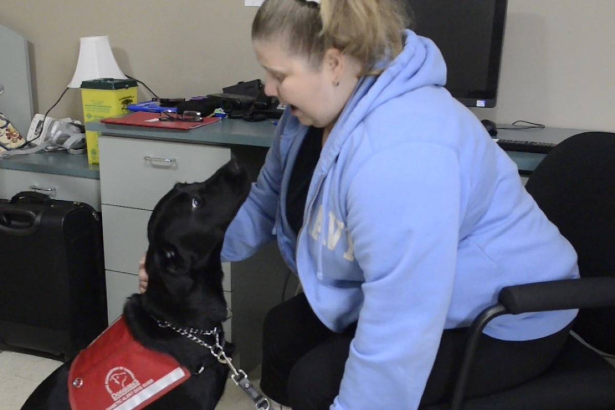 Carrie Lemay meets her new alert dog, Freckles, in Oakville, Ontario. (The Canadian Press)