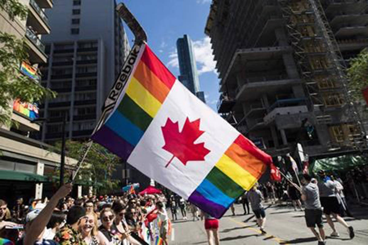 A man holds a flag on a hockey stick during the Pride parade in Toronto, Sunday, June 25, 2017. (Mark Blinch/The Canadian Press)