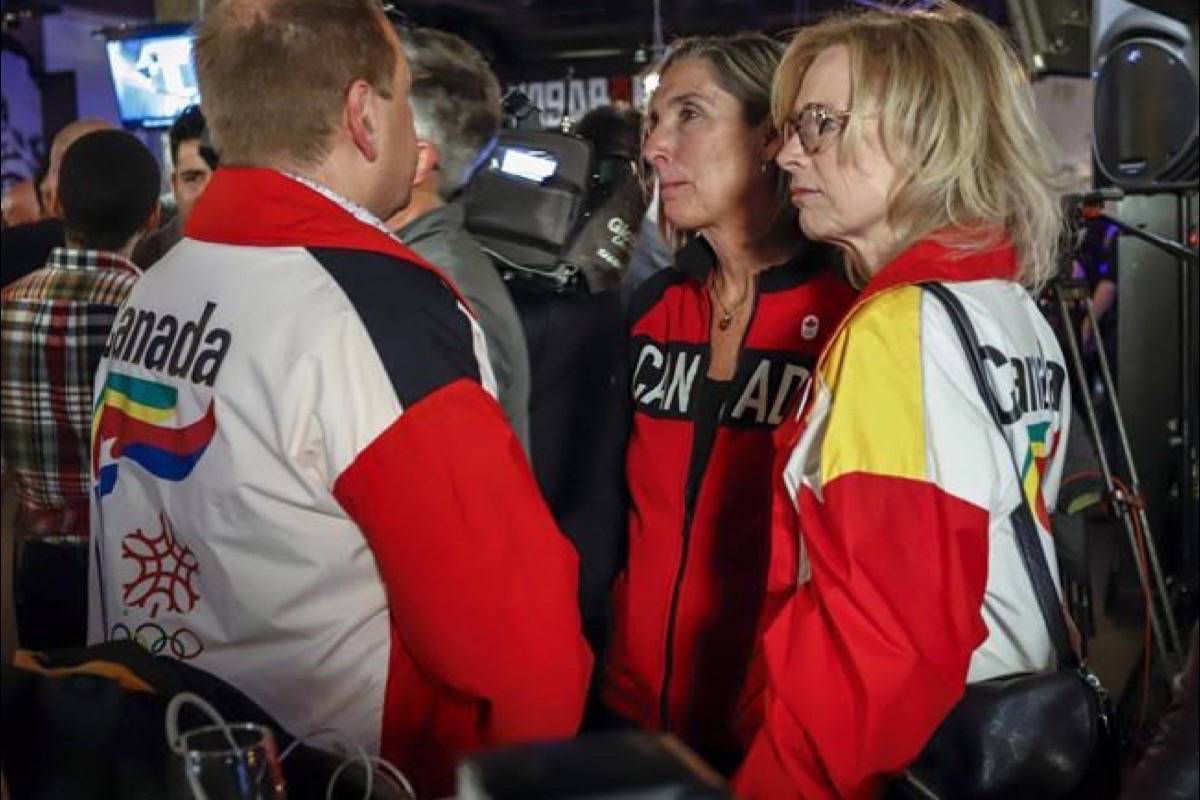 Dave King, left, Linda King, right, son and daughter of Frank King, wearing 1988 Calgary Olympic jackets react to the results of a plebiscite on whether the city should proceed with a bid for the 2026 Winter Olympics, in Calgary, Alta., Tuesday, Nov. 13, 2018. Calgary city council has hammered the final nail in the coffin of a bid for the 2026 Winter Olympics and Paralympic Games. (Jeff McIntosh/The Canadian Press)