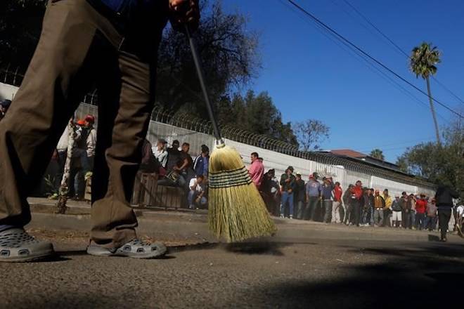 Central American migrants sweep outside the shelter where they are staying in Tijuana, Mexico, Sunday, Nov. 18, 2018. (AP Photo/Marco Ugarte)