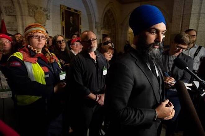 Surrounded by members of Canada Post NDP leader Jagmeet Singh listens to a question from the media about back to work legislation Friday November 23, 2018 in Ottawa. THE CANADIAN PRESS/Adrian Wyld