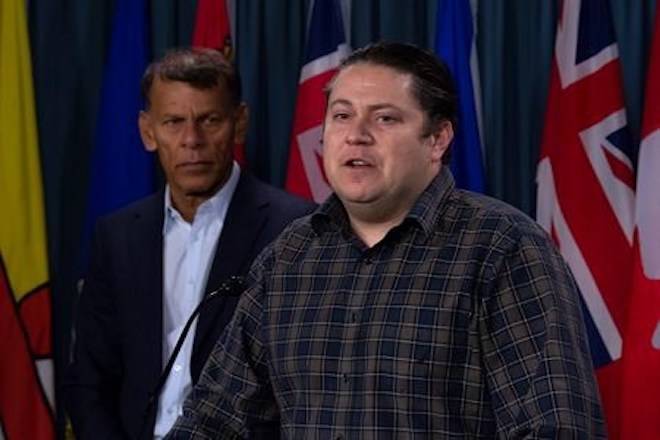 Canadian Labour Congress President Hassan Yussuff looks on as Canadian Union of Postal Workers President Mike Palecek speaks during a news conference on Parliament Hill Friday November 23, 2018 in Ottawa. THE CANADIAN PRESS/Adrian Wyld