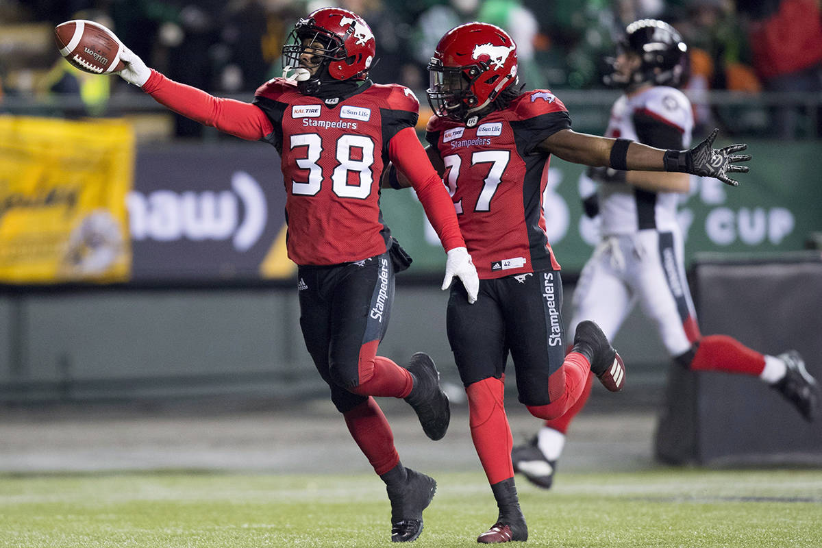 Calgary Stampeders running back Terry Williams (38) celebrates a punt return touchdown against the Ottawa Redblacks with teammate defensive back Tunde Adeleke (27) during the first half of the 106th Grey Cup in Edmonton, Alta. Sunday, Nov. 25, 2018. THE CANADIAN PRESS/Darryl Dyck