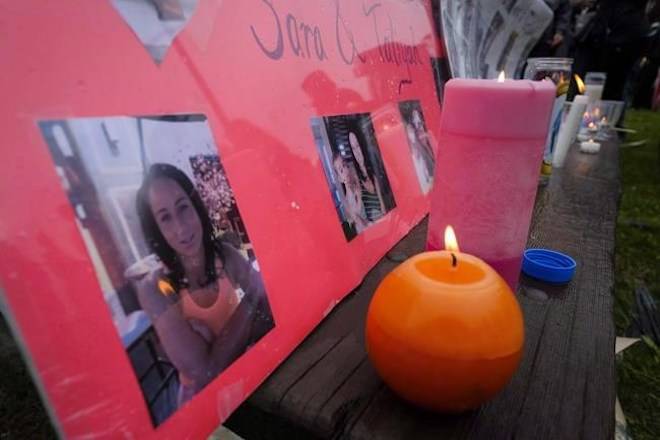 Lit candles and photographs are seen on display at a vigil for Calgary homicide victims Sara Baillie and her five-year-old daughter Taliyah Marsman, in Calgary, on July 17, 2016. THE CANADIAN PRESS/Jeff McIntosh