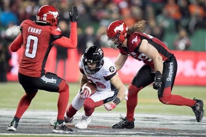 Calgary Stampeders defensive back Ciante Evans (0) and Stampeders linebacker Alex Singleton (49) try and stop Ottawa Redblacks wide receiver Brad Sinopoli (88) during the second half of the 106th Grey Cup in Edmonton, Alta. Sunday, Nov. 25, 2018. THE CANADIAN PRESS/Darryl Dyck