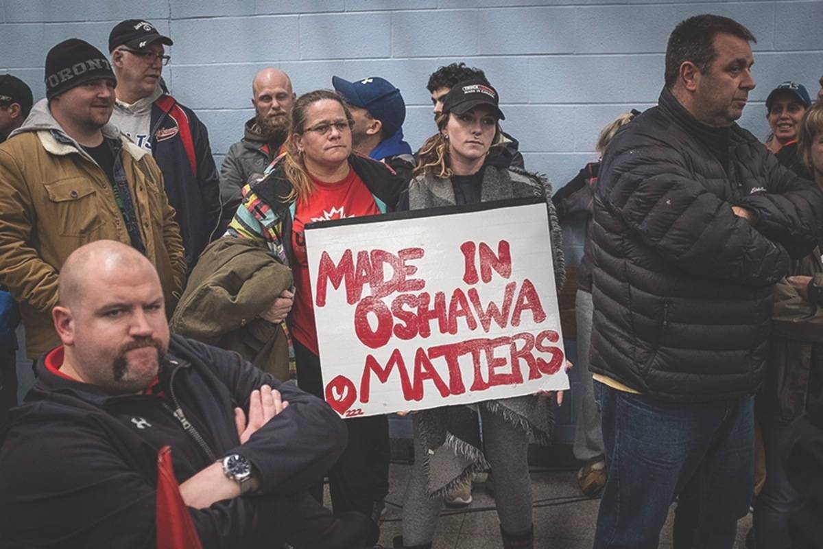 Laurie Nickel, centre left, and her daughter Stephanie hold a protest sign during the UNIFOR union meeting between the workers of Oshawa’s General Motors plant with Jerry Dias, president of UNIFOR, Monday, Nov. 26, 2018. The plant, which employs more than 2,500 people, is set to close. (Eduardo Lima/The Canadian Press)