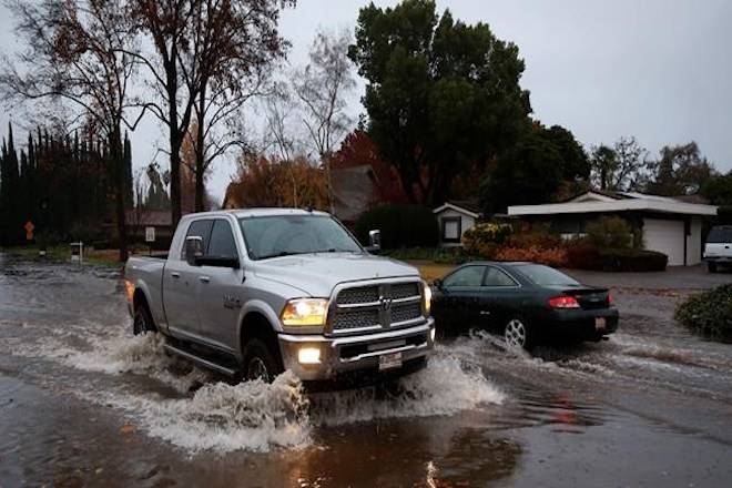 Vehicles pass each other on a flooded street Thursday, Nov. 29, 2018, in Chico, Calif. Flash flooding hit a wildfire-scarred area of Northern California on Thursday, forcing officials to deploy swift water rescue teams to save people stuck in vehicles and rescue them from homes after a downpour near the Paradise area. (AP Photo/Rich Pedroncelli)