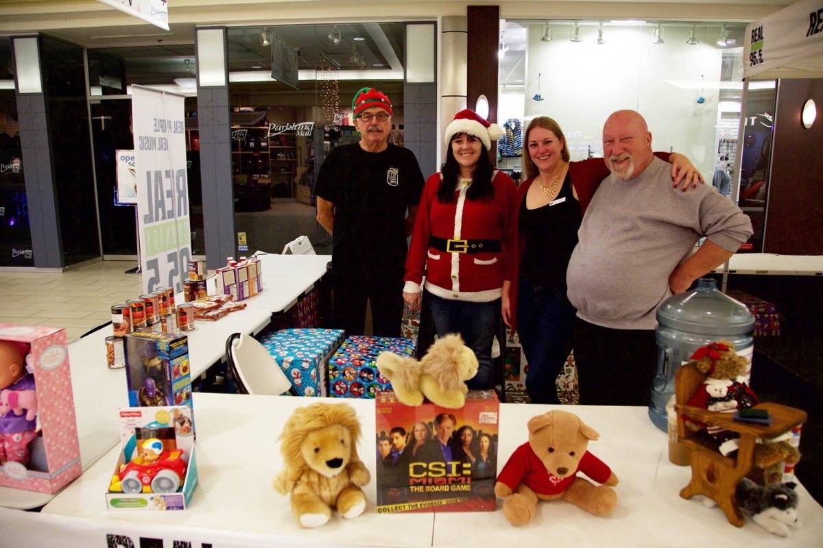 From left, Red Deer Food Bank Volunteer John Bittorf, Volunteer Co-ordinator with the Red Deer Food Bank Society Sheila Wetherelt, Event Co-ordinator with the Red Deer Christmas Bureau Teresa Patterson and Food Bank Executive Director Fred Scaife pose for a photo Thursday morning after the launch of Stuff-a-Bus at Parkland Mall. Robin Grant/Red Deer Express