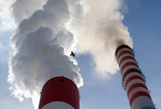 In this photo taken Wednesday, Oct. 3, 2018, a bird flies past as smoke emits from the chimneys of Serbia’s main coal-fired power station near Kostolac, Serbia. The COP 24 UN Climate Change Conference is taking place in Katowice, Poland. Negotiators from around the world are meeting for talks on curbing climate change. (AP Photo/Darko Vojinovic)