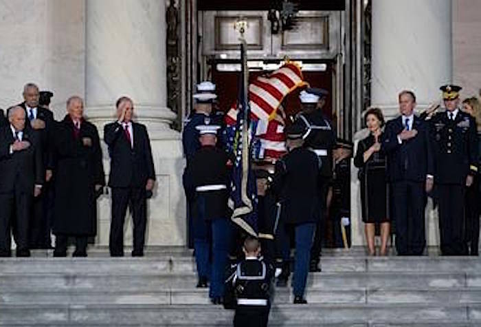 Family members and others watch as the flag-draped of former President George H.W. Bush is carried by a joint services military honor guard to lie in state in the rotunda of the U.S. Capitol, Monday, Dec. 3, 2018, in Washington. (Doug Mills/The New York Times via AP, Pool)