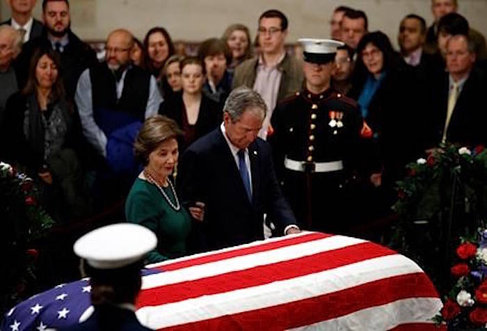Former President George W. Bush and former first lady Laura Bush pause in front of the flag-draped casket of former President George H.W. Bush as he lies in state in the Capitol’s Rotunda in Washington, Tuesday, Dec. 4, 2018. (AP Photo/Patrick Semansky)