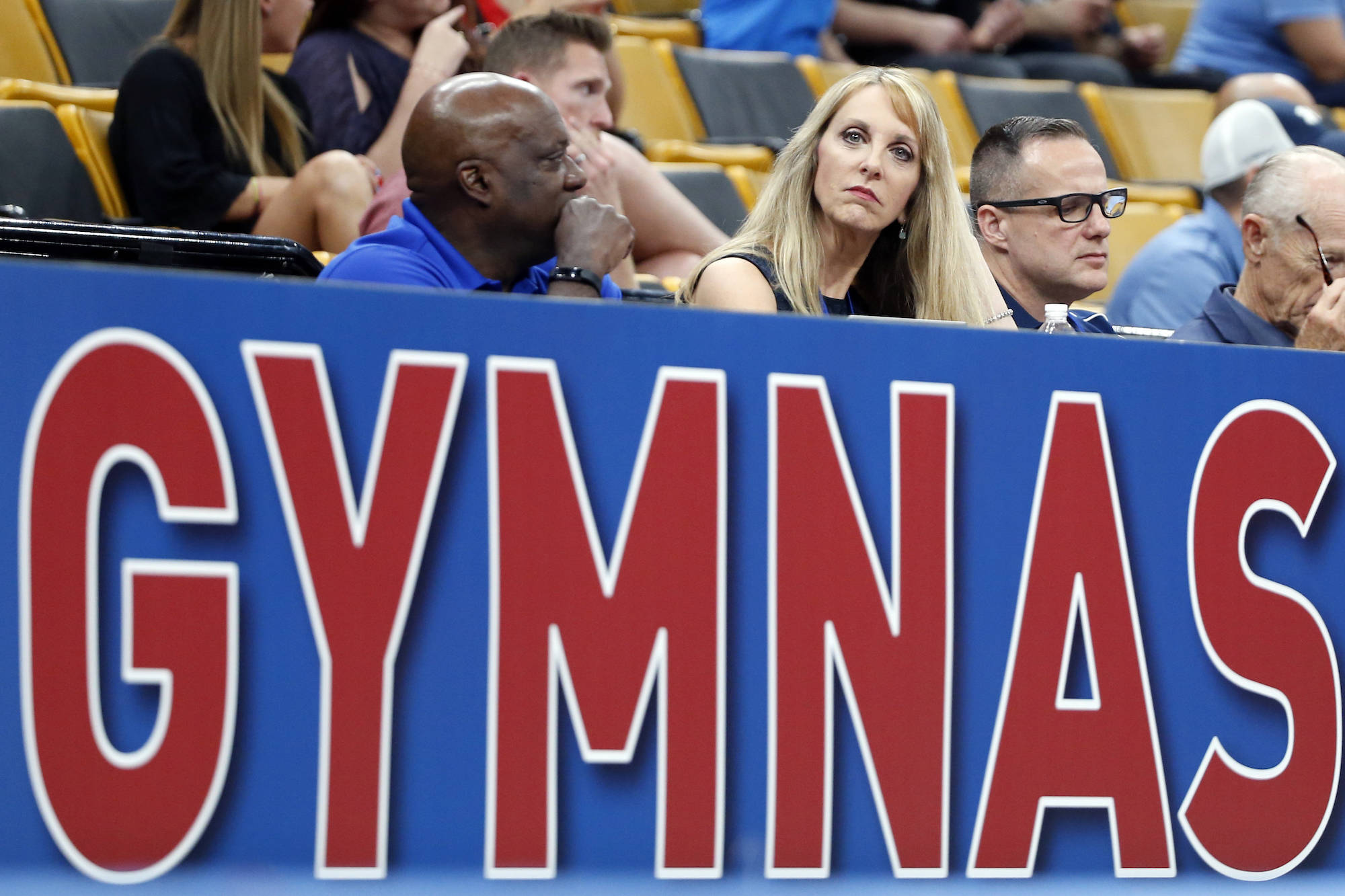 USA Gymnastics President and CEO Kerry Perry, middle, watches the U.S. Gymnastics Championships, Thursday, Aug. 16, 2018, in Boston. (AP Photo/Elise Amendola)