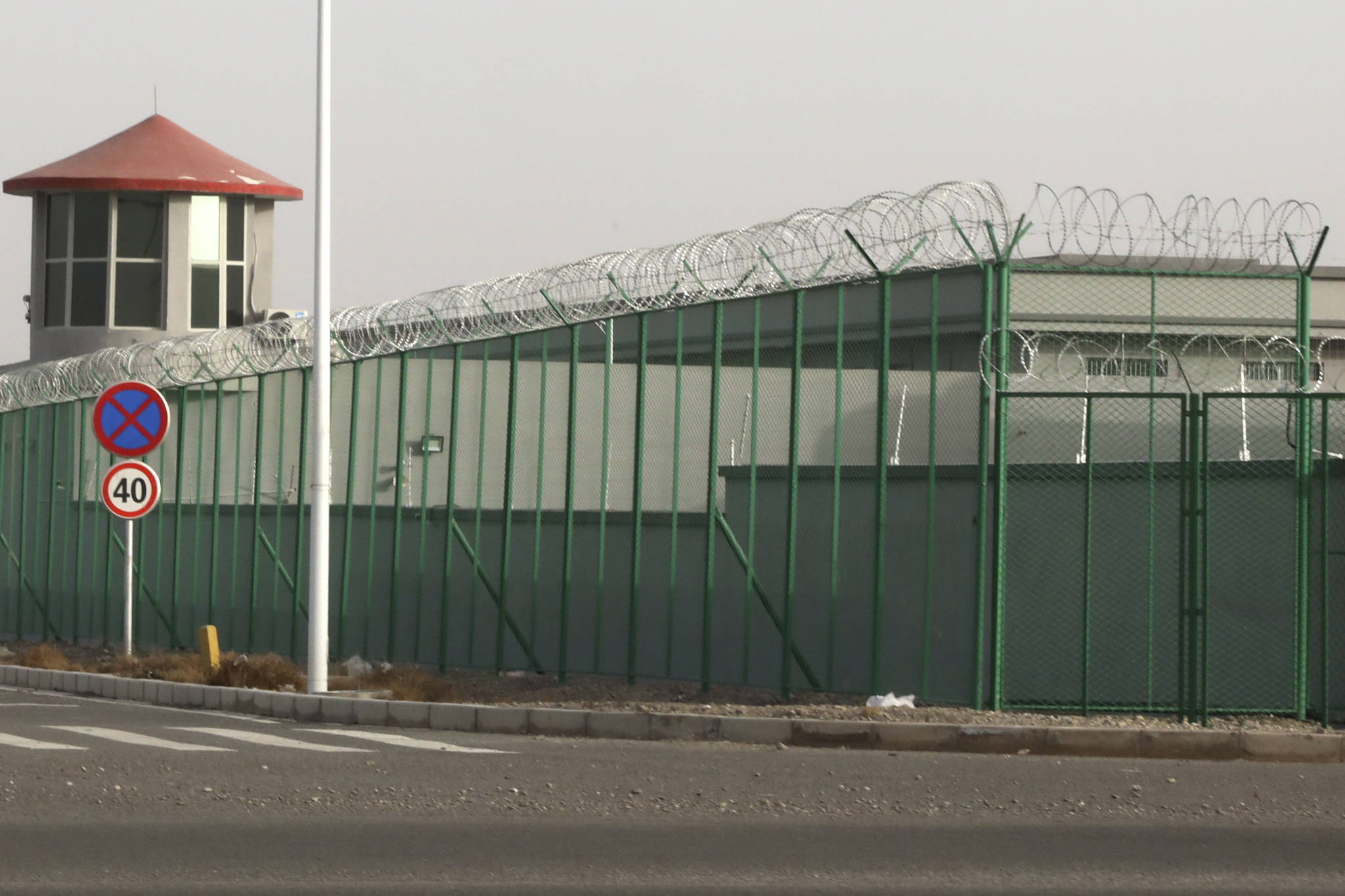 In this Monday, Dec. 3, 2018, photo, a guard tower and barbed wire fences are seen around a facility in the Kunshan Industrial Park in Artux in western China’s Xinjiang region. (AP Photo/Ng Han Guan)