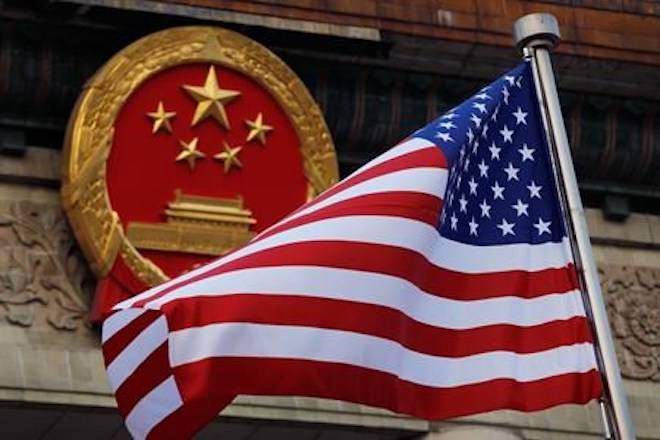 FILE - In this Nov. 9, 2017, file photo, an American flag is flown next to the Chinese national emblem during a welcome ceremony at the Great Hall of the People in Beijing. (AP Photo/Andy Wong, File)