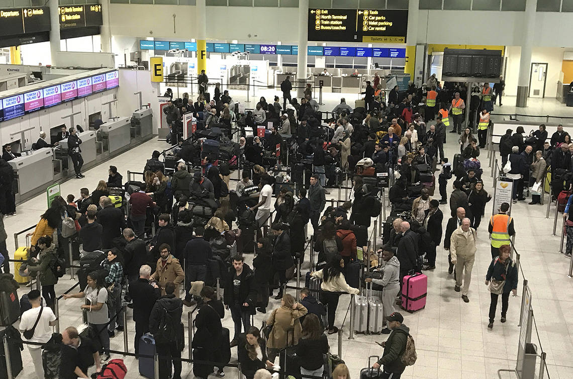 Passengers wait to check in at Gatwick Airport in England, Friday, Dec. 21, 2018. Flights resumed at London’s Gatwick Airport on Friday morning after drones sparked the shutdown of the airfield for more than 24 hours, leaving tens of thousands of passengers stranded or delayed during the busy holiday season. (AP Photo/Kirsty Wigglesworth)