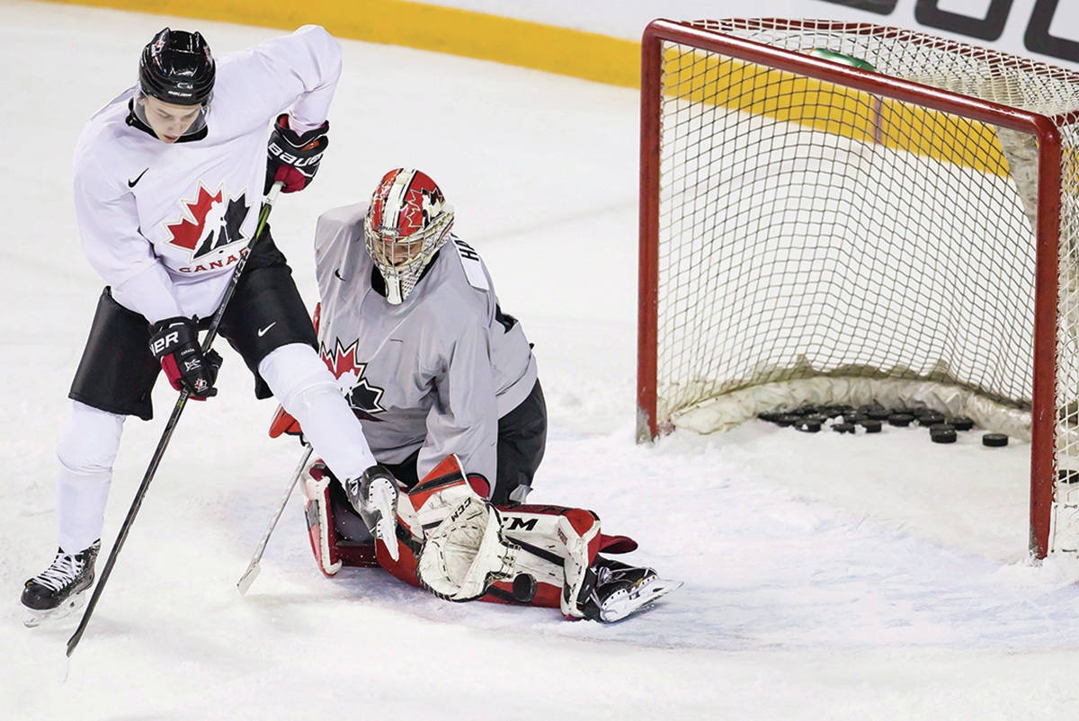 Canadian national junior team goaltending prospect Carter Hart, right, makes a pad save while being screened by forward Cody Glass on the first day of selection camp for the 2018 World Junior Hockey Championship in St.Catharines, Ont., Tuesday, December 12, 2017. (Aaron Lynett/The Canadian Press)