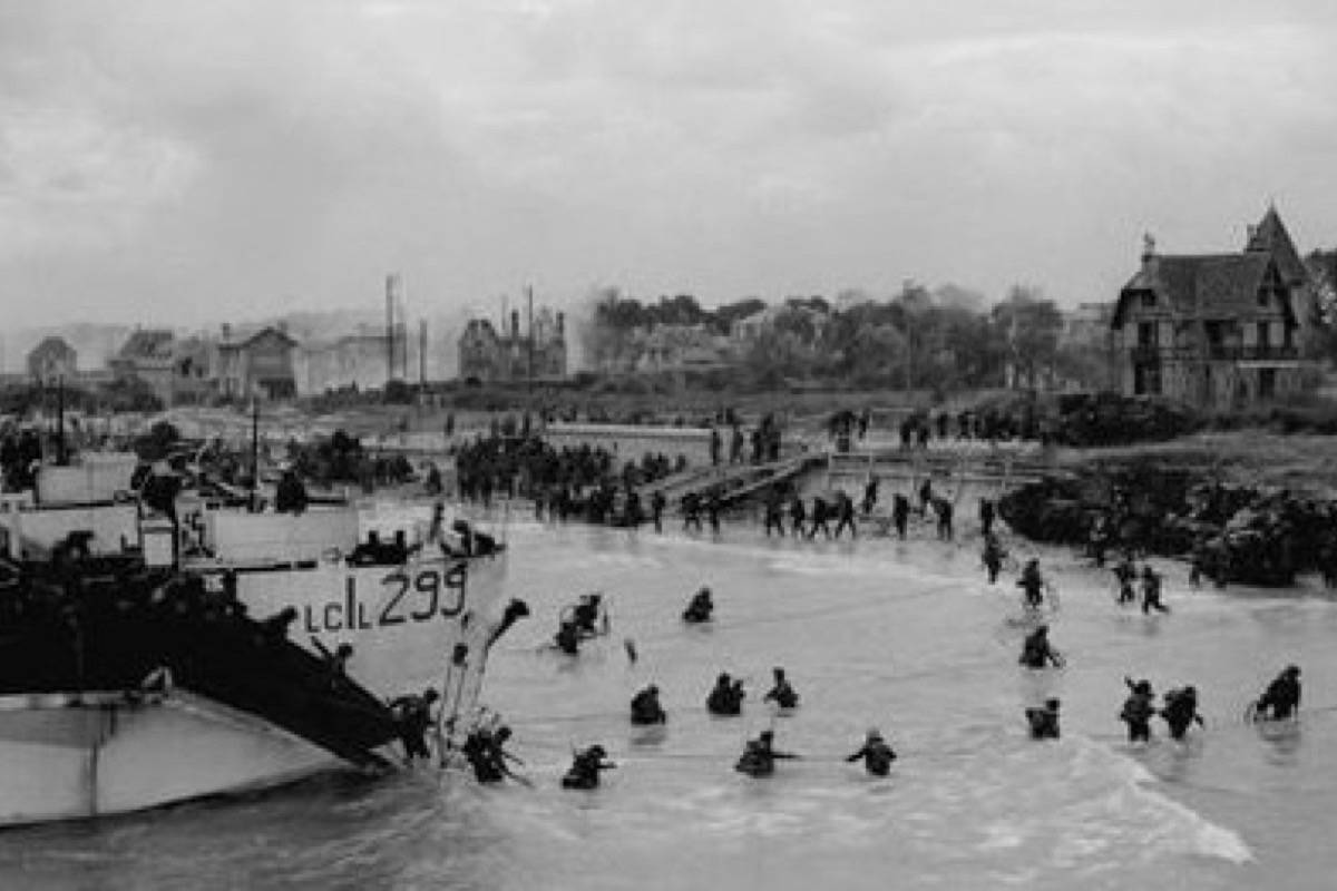 View looking east along ‘Nan White’ Beach, showing personnel of the 9th Canadian Infantry Brigade landing from LCI(L) 299 of the 2nd Canadian (262nd RN) Flotilla on D-Day. (CP PHOTO) 1998 (National Archives of Canada-Gilbert Alexandre Milne) PA-137013