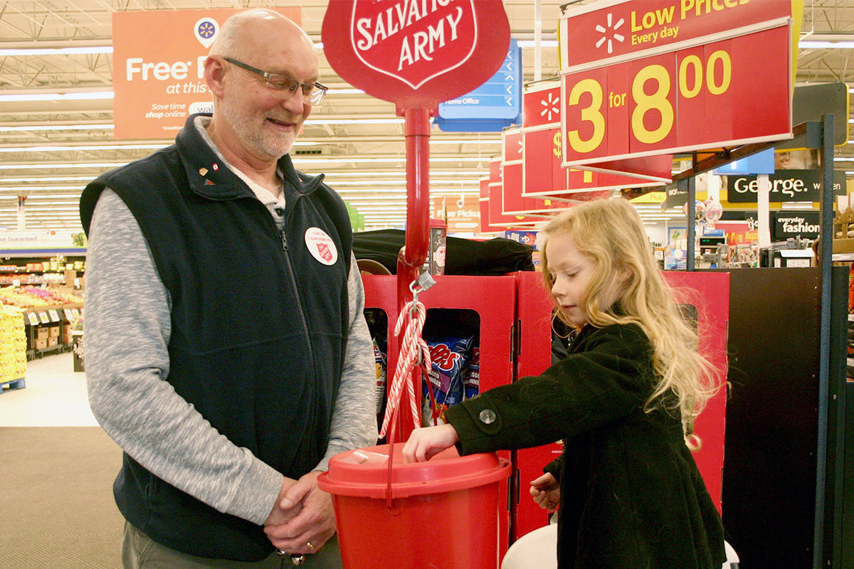 A Salvation Army volunteer smiles as a young girl donates money. (Black Press Media file photo)