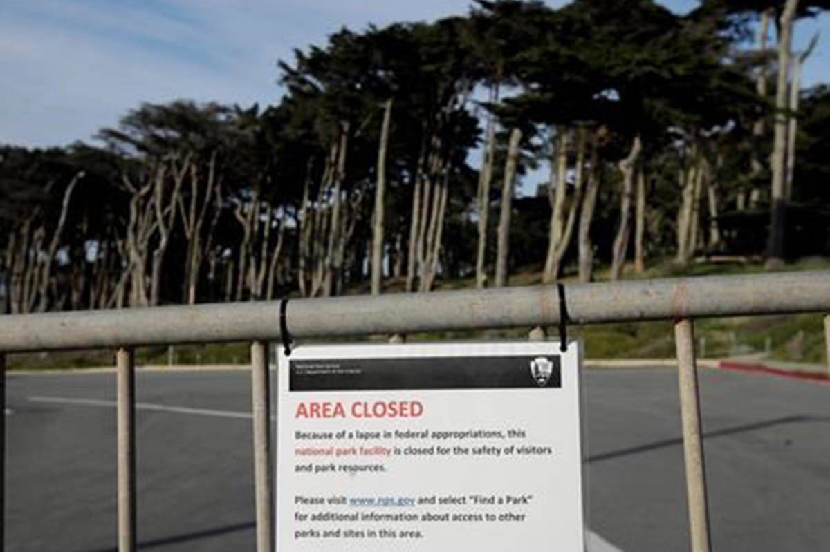 A sign is posted on a gate blocking a parking lot to Land’s End in San Francisco, Thursday, Jan. 3, 2019. Nonprofits, businesses and state governments across the country are paying bills and putting in volunteer hours in an uphill battle to keep national parks safe and clean for visitors as the partial U.S. government shutdown lingers. (AP Photo/Jeff Chiu)