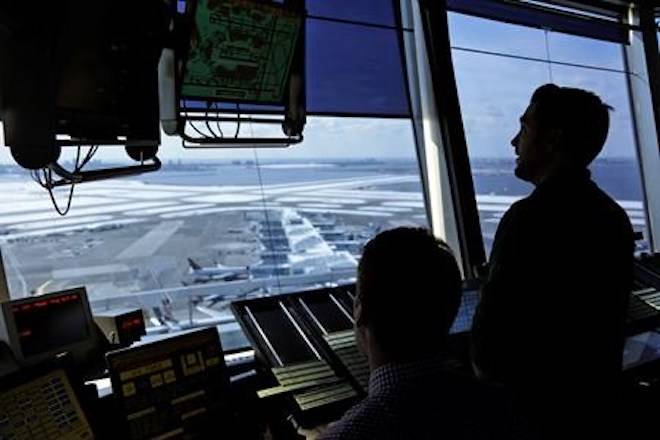 FILE - In this March 16, 2017, file photo, air traffic controllers work in the tower at John F. Kennedy International Airport in New York. (AP Photo/Seth Wenig, File)