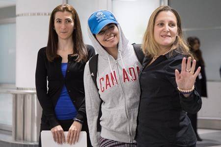 Saudi teenager Rahaf Mohammed Alqunun, centre, stands with Canadian Minister of Foreign Affairs Chrystia Freeland, right, as she arrives at Toronto Pearson International Airport, on Saturday, January 12, 2019. (THE CANADIAN PRESS/Chris Young)