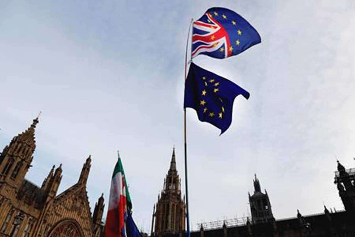 A Pro-European demonstrator raises flags to protest outside parliament in London, Friday, Jan. 11, 2019. Britain’s Prime Minister Theresa May is struggling to win support for her Brexit deal in Parliament. Lawmakers are due to vote on the agreement Tuesday, and all signs suggest they will reject it, adding uncertainty to Brexit less than three months before Britain is due to leave the EU on March 29. (AP Photo/Frank Augstein)