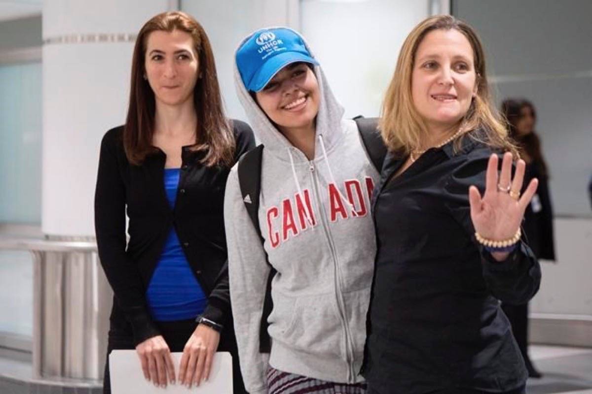 Saudi teenager Rahaf Mohammed Alqunun, centre, stands with Canadian Minister of Foreign Affairs Chrystia Freeland, right, as she arrives at Toronto Pearson International Airport, on Saturday, January 12, 2019. (Chris Young/The Canadian Press)