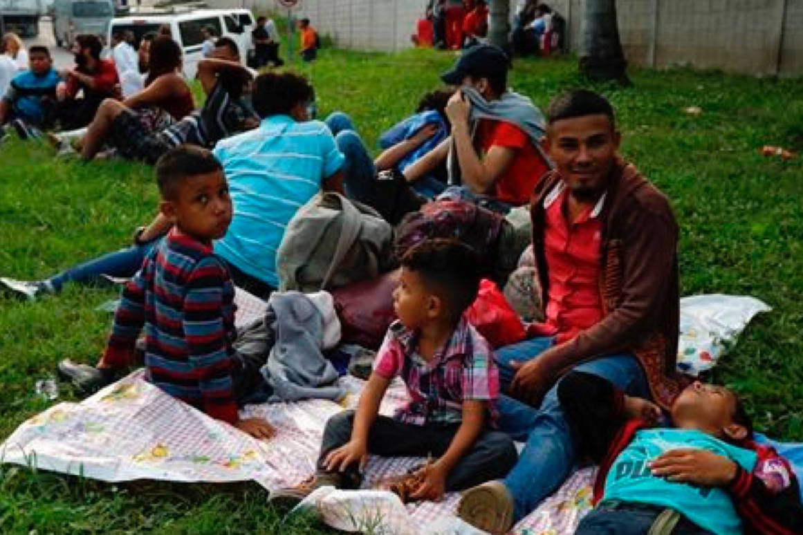 Freddy Rivas, second right, of Tocoa, Honduras, sits with his sons Josue, left, and Elkin, center, and his brother Mario, as they wait with scores of other migrants hoping to join a caravan to travel to the U.S. border, in San Pedro Sula, Honduras, Monday, Jan. 14, 2019. Hundreds of Hondurans hoping to reach the U.S. began gathering at a main bus station in San Pedro Sula Monday night to join a caravan that had been advertised in social media as departing in the early hours of Tuesday morning. (AP Photo/Delmer Martinez)